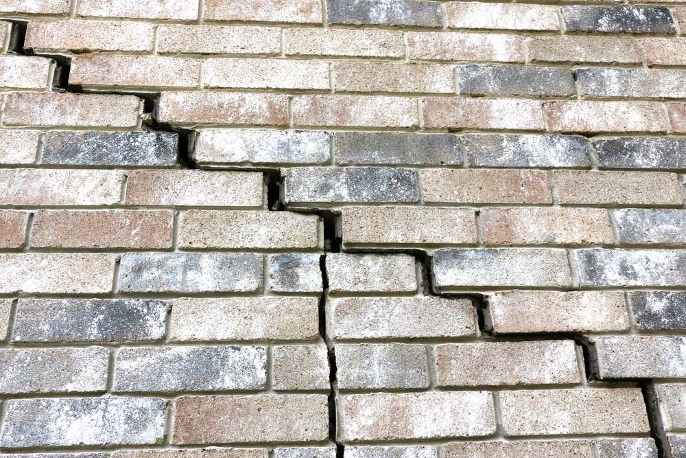Stair-step crack in brick exterior — a classic foundation settlement sign